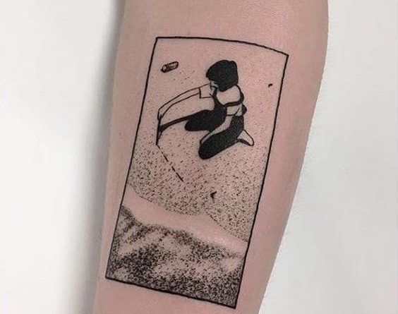 Девочка, играющая на татуировке на пляже
